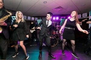  The wedding band and singers performing a synchronized dance while they sing