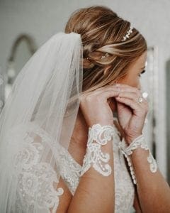 Bride putting on her earrings