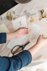  Hands holding silk ribbon over a stationery suite