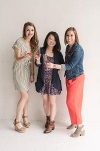 Three smiling women toasting with champagne flutes