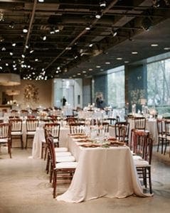  A wedding reception setup at Marie Gabrielle with white linens and brown bistro chairs