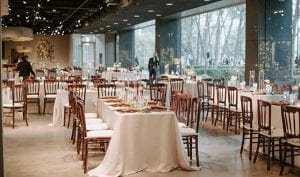  A wedding reception setup at Marie Gabrielle with white linens and brown bistro chairs